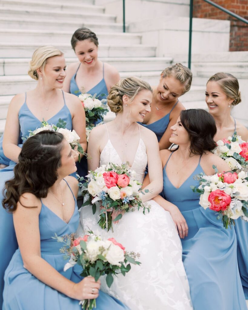 Girl in a wedding dress smiling while adjusting sandals